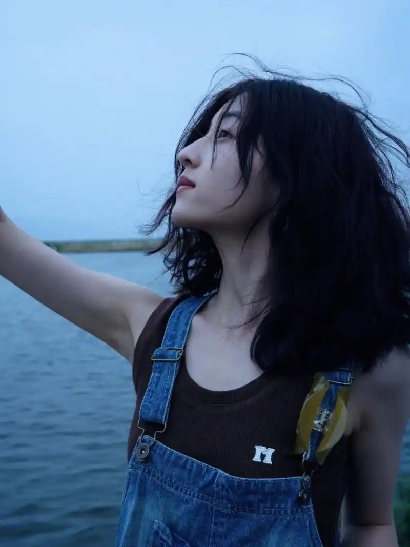 张子枫晒出一组海边随拍 身穿vintage古着牛仔背带连衣裙, 内搭咖色坑