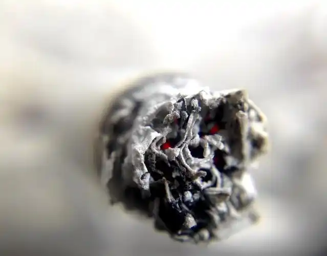 the end of a cigarette resembling a skull with glowing eyes