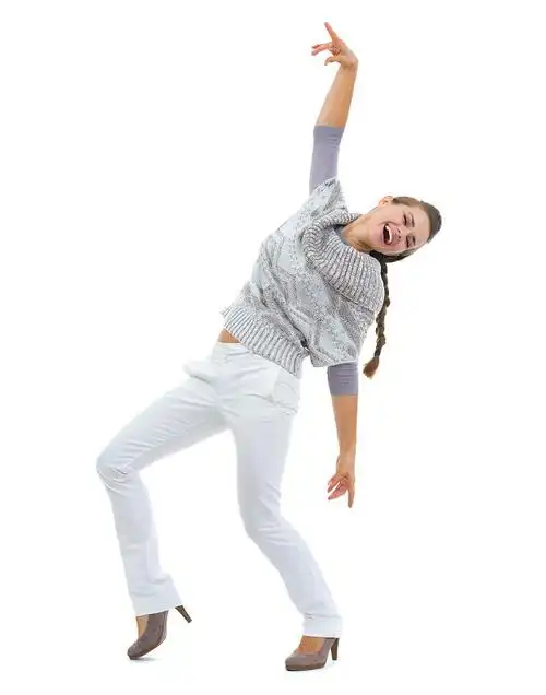 全身像快乐的年轻女子在毛衣跳舞图片下载