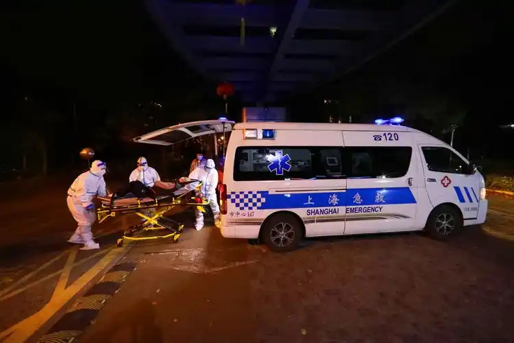 随车医生钟金生(中),急救员邓建亮试着将一名高血压患者抬进120急救车