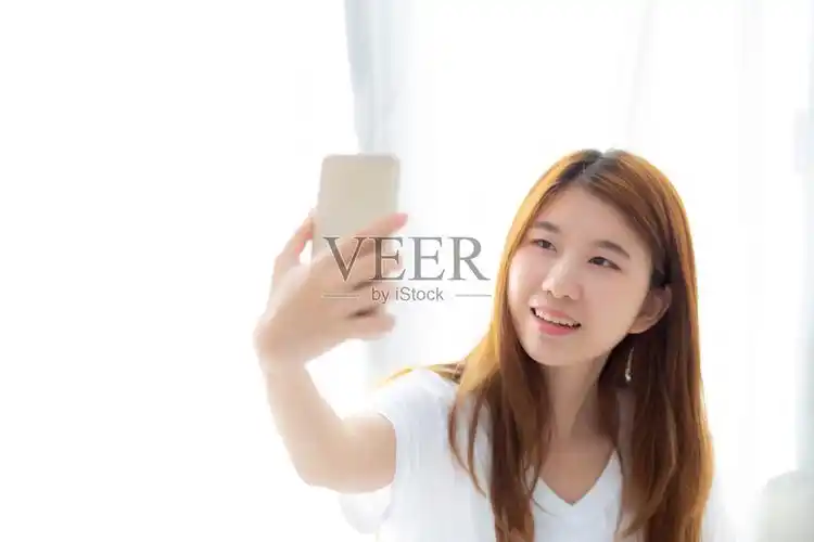 美丽的肖像年轻的亚洲女人用智能手机自拍在卧室早上在家里女孩是拍照