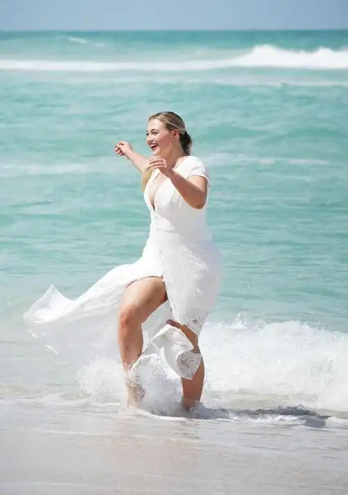 大码模特伊斯卡劳伦斯现身海边穿白色连身裙气派十足笑容甜美