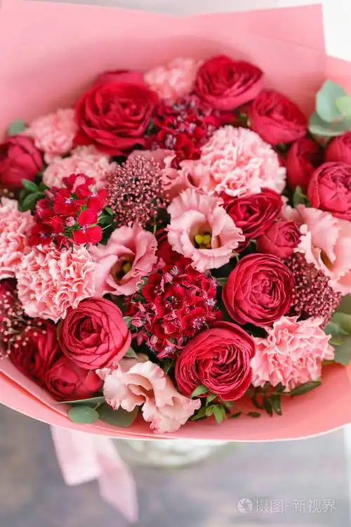 在木桌上的美丽的花朵鲜艳的红色花束.植物概念.春天的颜色.