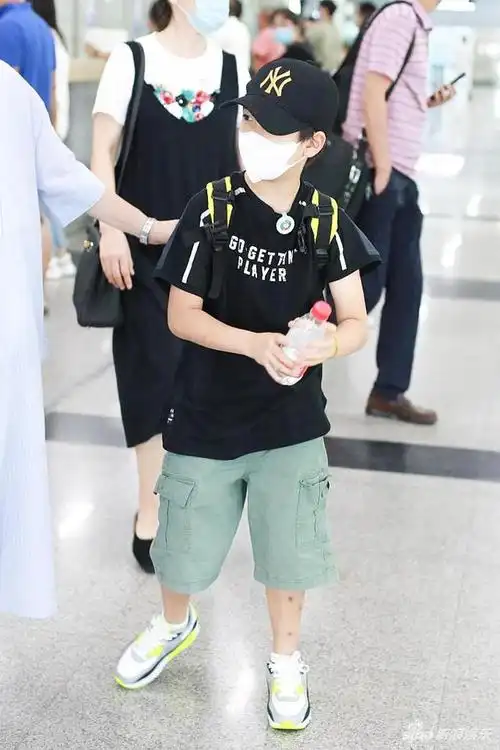 组图:郑钧带儿子搭机造型休闲 萌娃郑熙岳忙拧瓶盖笑眼可爱