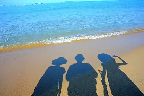 沙滩上一家三口的影子