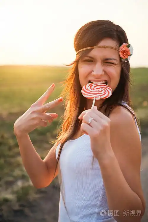 年轻的黑发女人吃棒棒糖