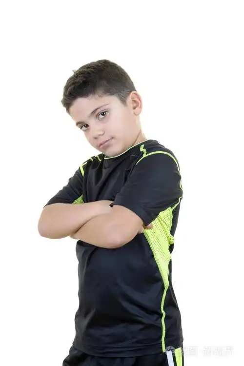 小男孩在白色背景面前摆出自信的姿势,展示了他的力量.