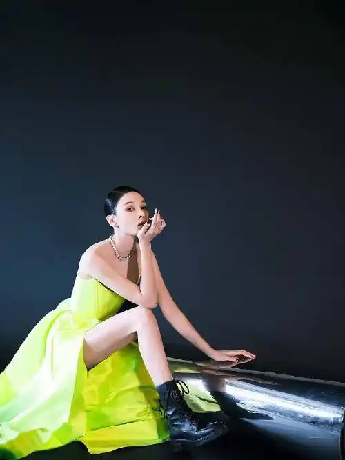 照片中,张蓝心穿荧光色长裙大秀美腿,马丁靴搭黑色美甲又酷又飒.