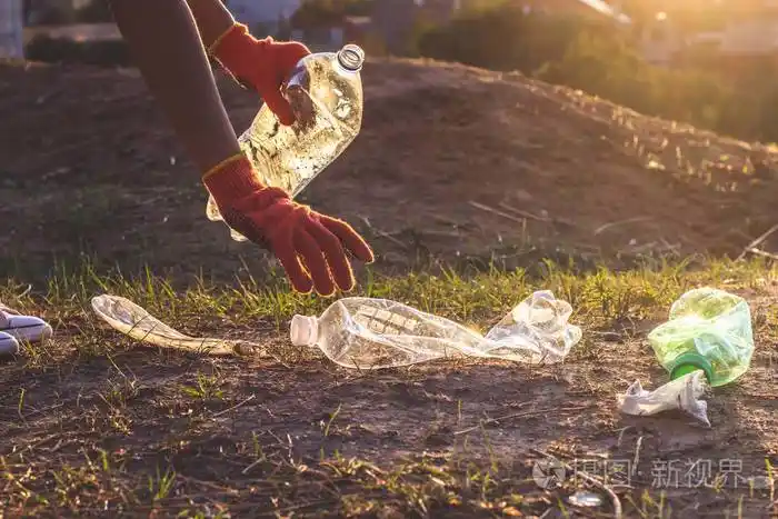 垃圾瓶被捡起来扔进垃圾袋.塑料和食物垃圾概念.