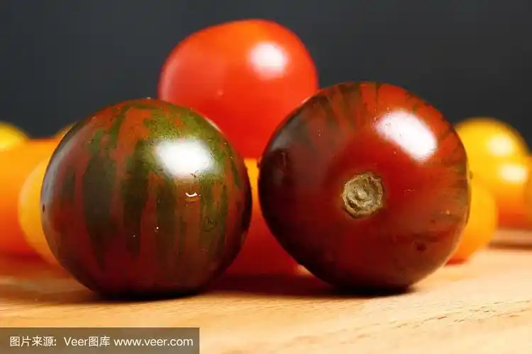 木质表面的黑色斑马番茄.宏.黑色背景.