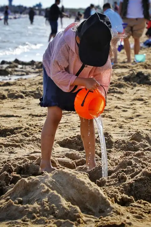 海边玩沙的小女孩