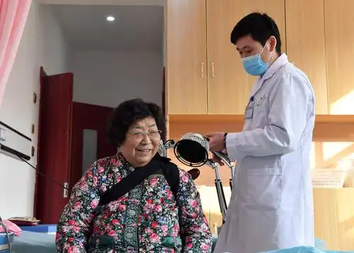 2月8日,在郑州爱睦家护理院,医护人员为老人做康复理疗.