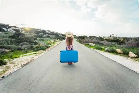 女人与蓝色的箱子路上的背影一位戴眼镜的年轻漂亮女子,背影孤零零地
