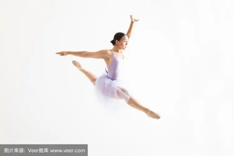 年轻的芭蕾舞演员在空中做劈叉白色的背景