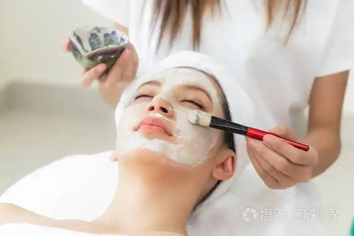 美丽的女人有一个面部美容擦洗治疗从专业皮肤科医生在健康水疗.