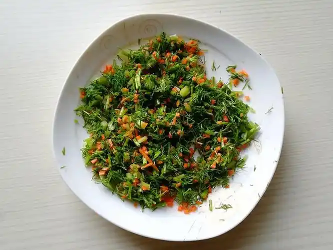 6.将茴香菜和胡萝卜末混合,加入少许盐,拌匀,腌制10分钟