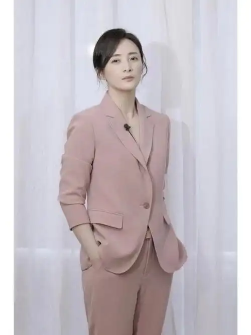 演员蒋勤勤身着ports宝姿2022秋冬系列灰月季粉套西,明亮色挺阔西装