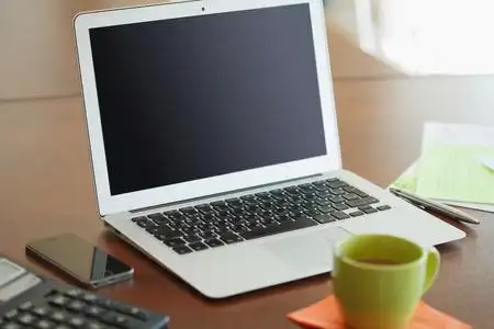 在现代的木桌子上打开笔记本电脑工作场所照片