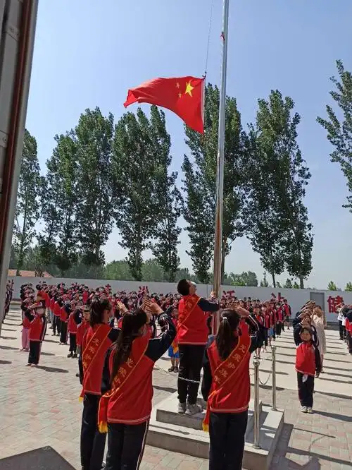 一年级新入队的少先队员,一同向国旗敬礼.