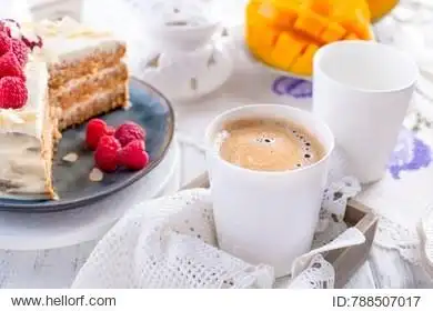 cut the cake with white cream, for breakfast. a mango fruit.