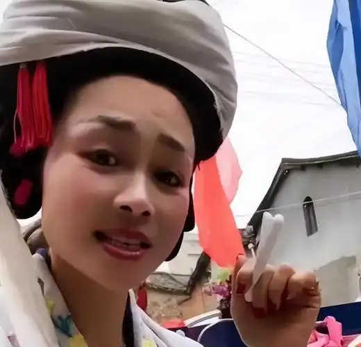 伴随着唢呐,笛,笙等乐器吹奏的曲调,一位头戴孝布的女子跪在灵堂前,望