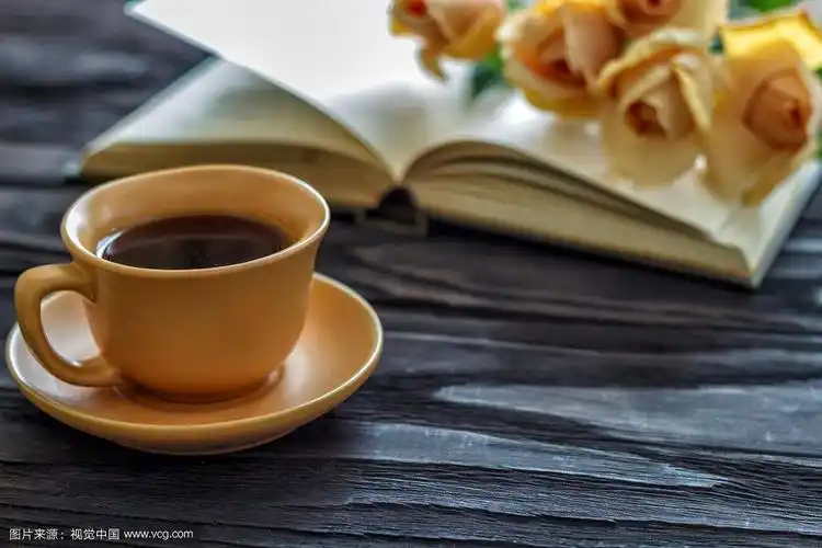 打开书杯与咖啡花玫瑰在一个木制背景与复印空间,俯视图