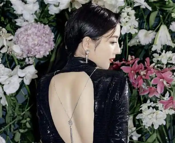 佟丽娅身穿露背礼服,在鲜花簇拥中展现性感的"背影杀",裸露的肌肤上