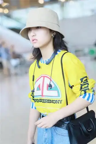 张子枫黄卫衣走机场配不规则裤腰显瘦牛仔裤剪俩洞时髦又清爽