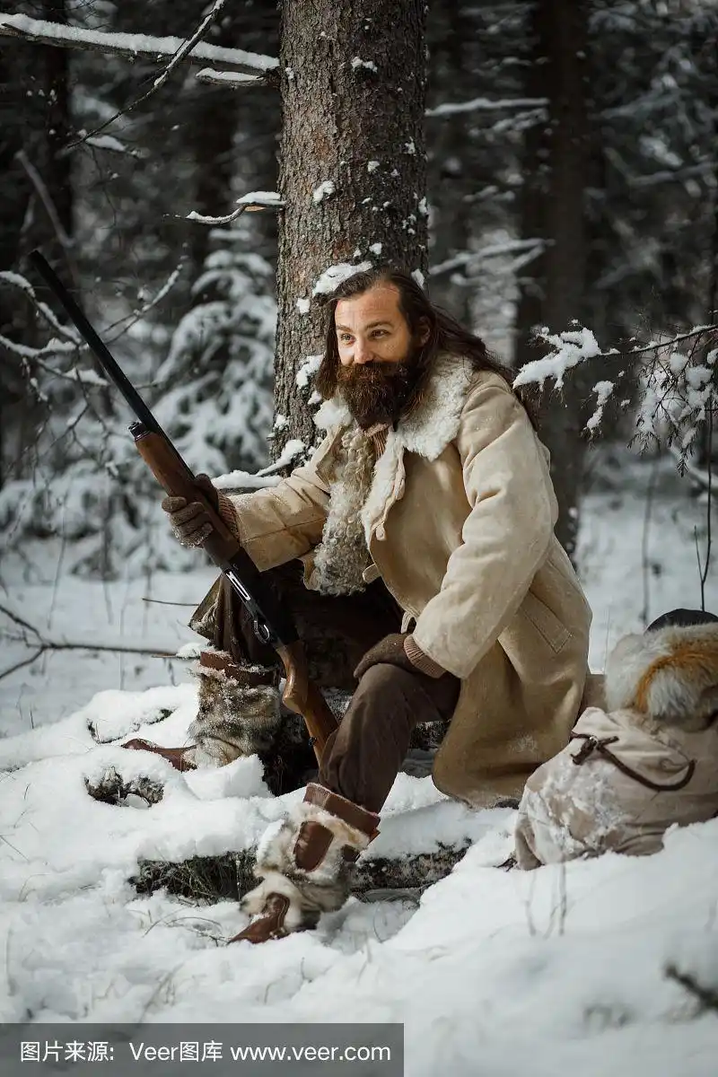 猎人在冬天穿着温暖的复古衣服,带着枪在冬天的森林里
