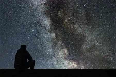 夜晚的天空,星星与剪影单独人看照片