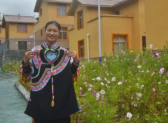 四川省凉山彝族自治州甘洛县蓼坪乡清水村的22岁姑娘王芳在展示她绣制