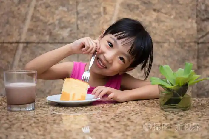亚洲中国小女孩吃美味的蛋糕