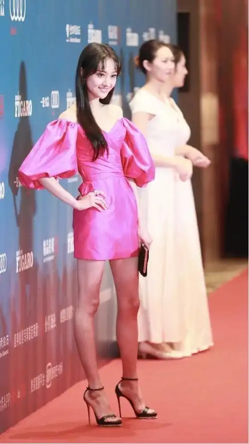 并没有选择同种颜色的鞋子搭配,而是穿上了一双黑色的高跟凉鞋,其实在