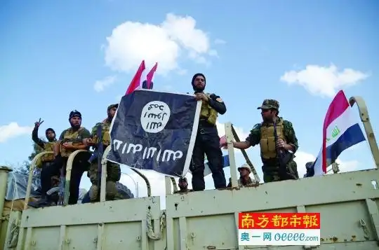 3月31日,在伊拉克提克里特,什叶派民兵展示缴获的"伊斯兰国"旗帜.