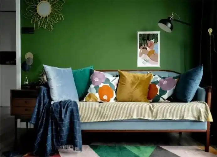 灰蓝色的绒面柔软舒适,是屋主喜欢的款式;沙发背景墙是墨绿色的,搭配