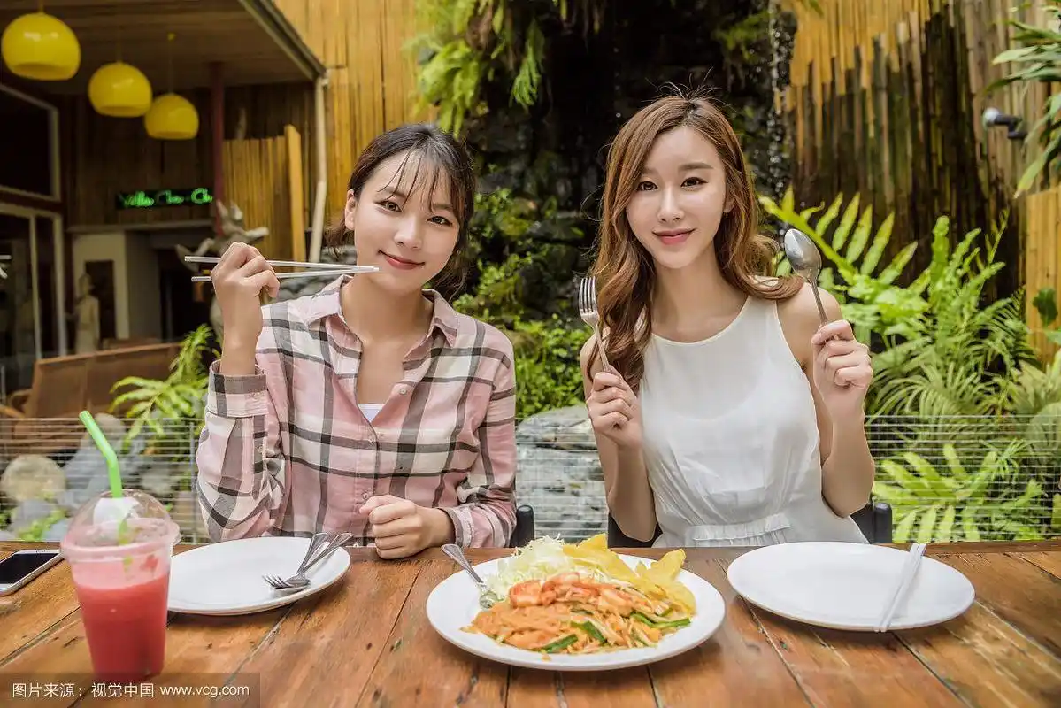 两个女人在泰国餐馆吃饭的照片