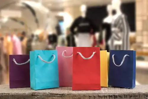 商店的木桌上有很多五颜六色的纸购物袋.前视图