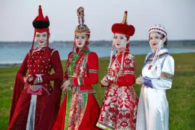 草原上穿着蒙古族传统服饰的亚洲年轻女性