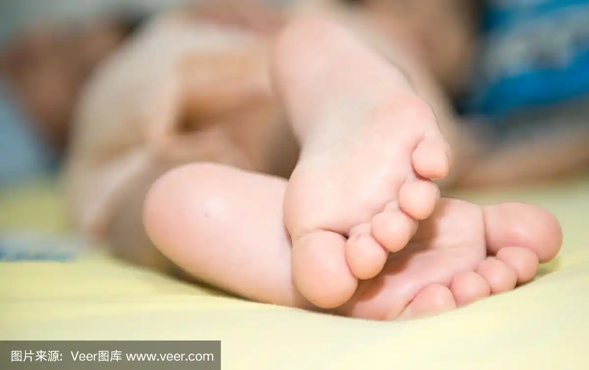 白色毯子上的小女孩的小脚