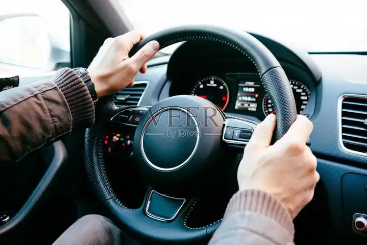 男人开着现代汽车在城市的交通中握着方向盘照片摄影图片