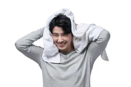 毛巾擦头发年轻男子在用毛巾擦头发照片