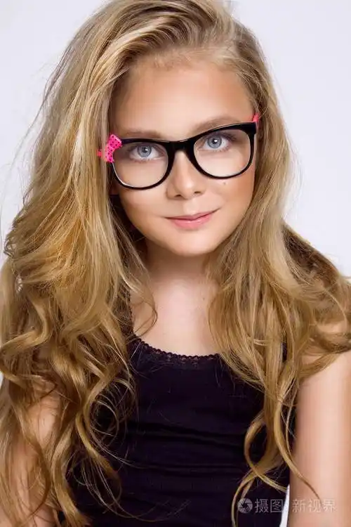 可爱的金发小女孩戴着白色背景的眼镜在工作室里