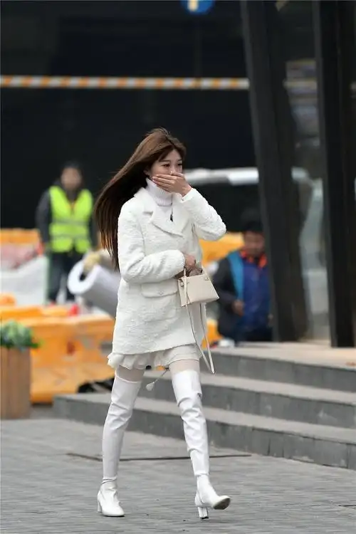 白色粗跟过膝靴搭配白色丝袜毛衣和外套都是白色的