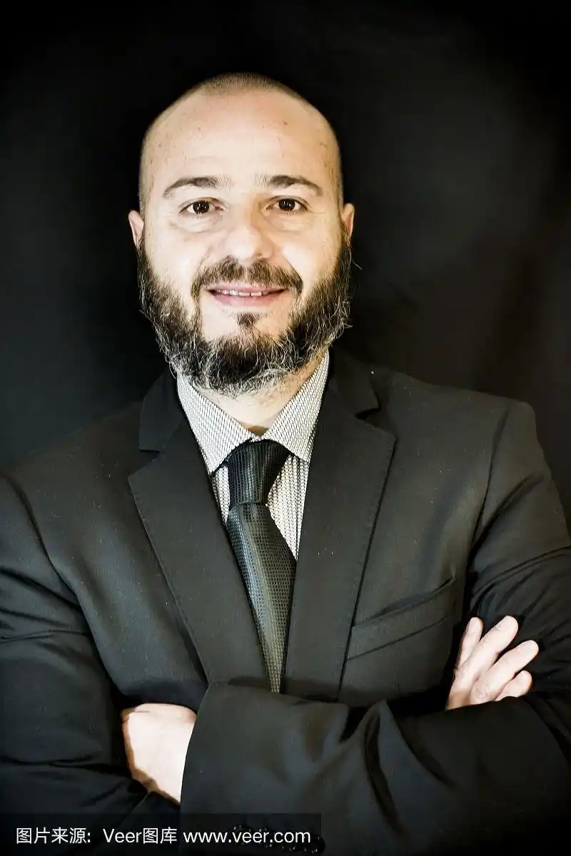 英俊的秃顶男子,胡子,西装和领带,在黑色背景