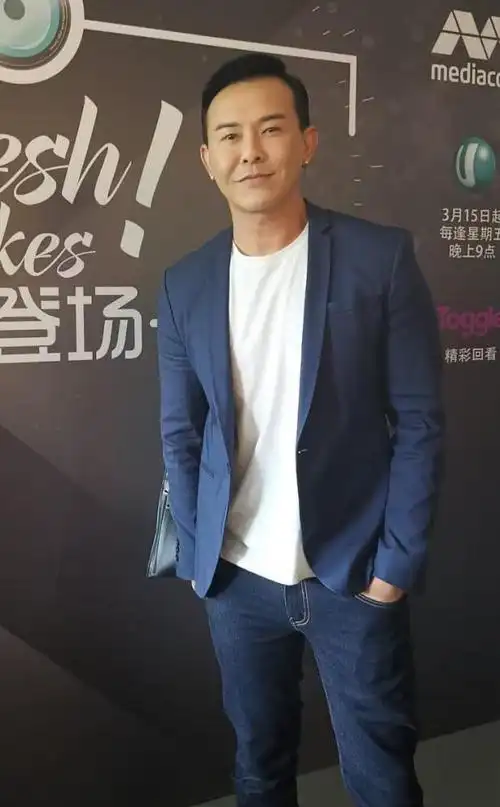 王禄江身穿着一件蓝色的西装外套,再搭配着一件简单的t恤衫,就显得很