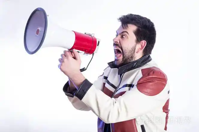 在演播室里对着白色背景的扩音器大声喊叫