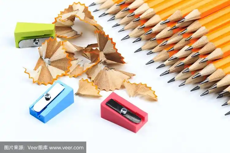 一堆黄色的铅笔和削铅笔刀孤立在白色的上面