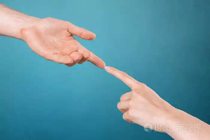 女人在蓝色背景上触摸男人手指的裁剪图像