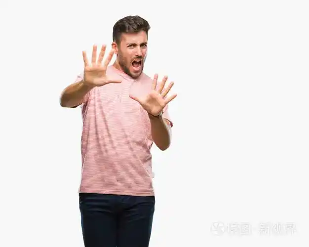 年轻英俊的男人在孤立的背景下害怕和恐惧的表情, 用手停止手势, 在