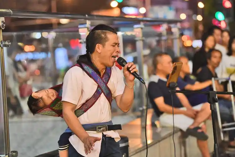 33岁奶爸背3岁娃街头卖唱,称唱歌没钱玩不起音乐,唱歌死路一条